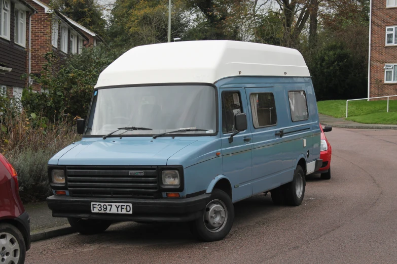 a blue van is parked in front of a building