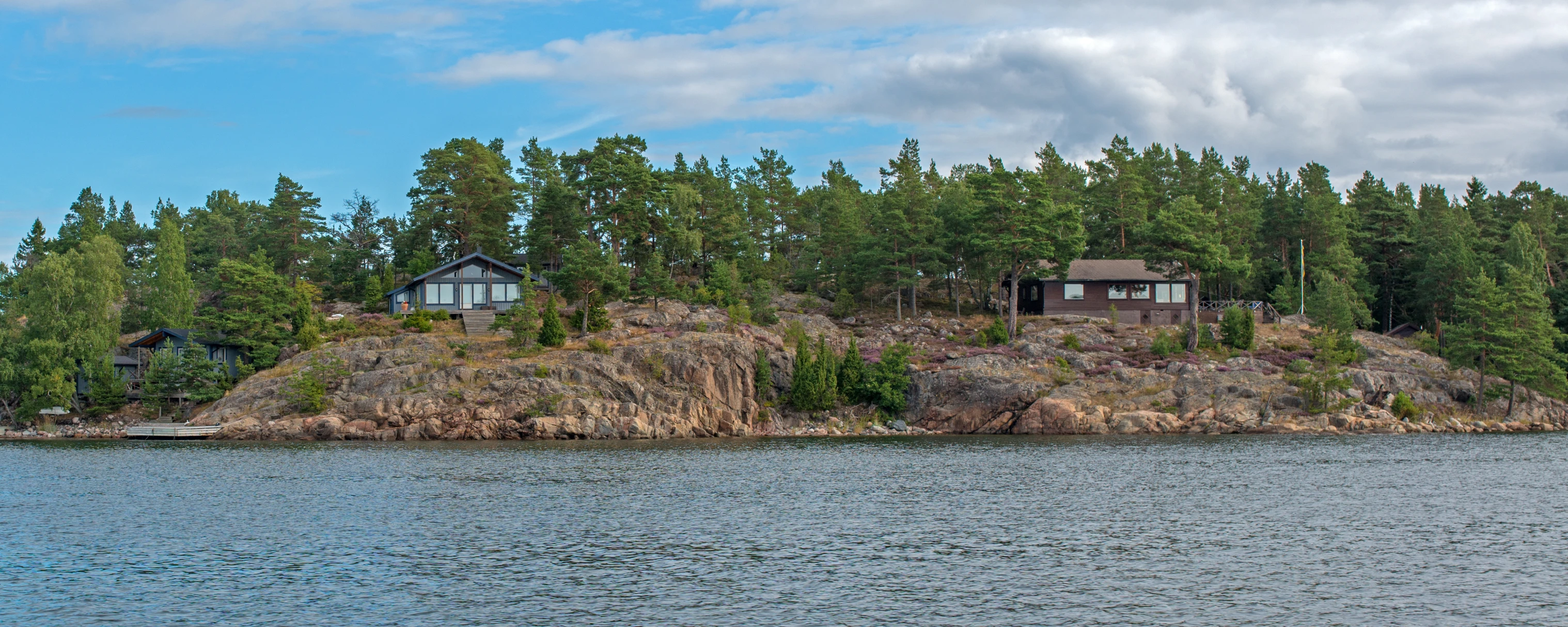 a boat cruises past houses on an island