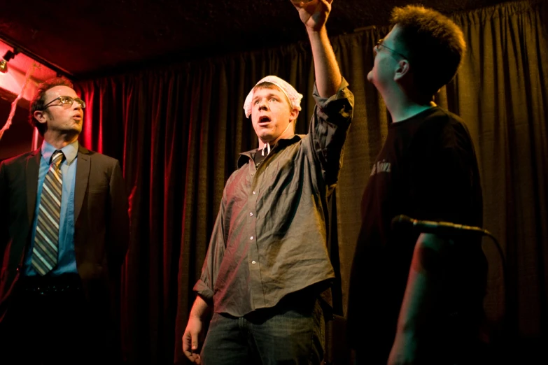 two men in a dimly lit room are observing soing up in the air