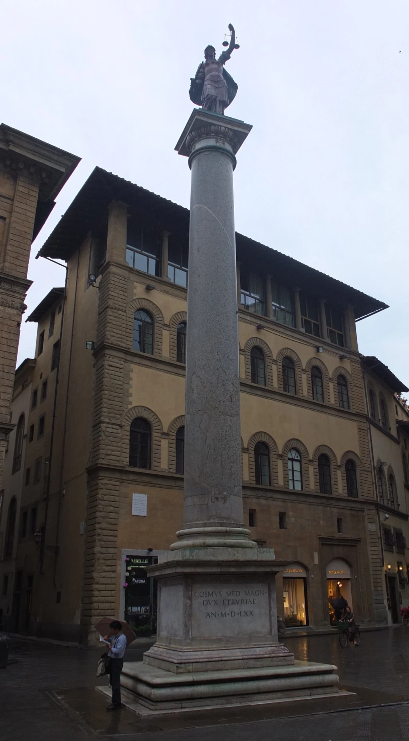 a statue of a man standing next to a building