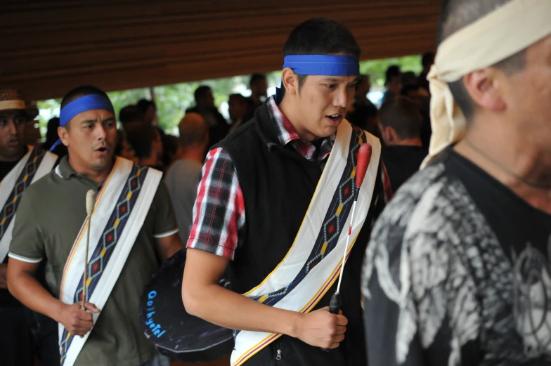 several men are standing in a group and carrying sashes