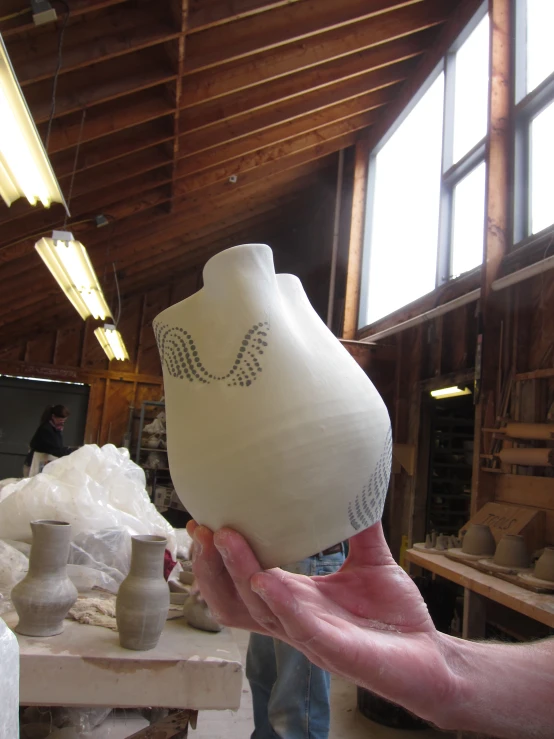 a person is holding a jug with a diamond pattern on it