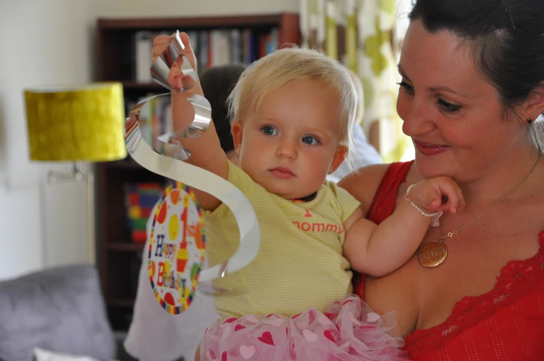 a lady holding a baby girl with one arm