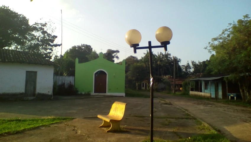 a large yellow bench sitting in the middle of an empty street