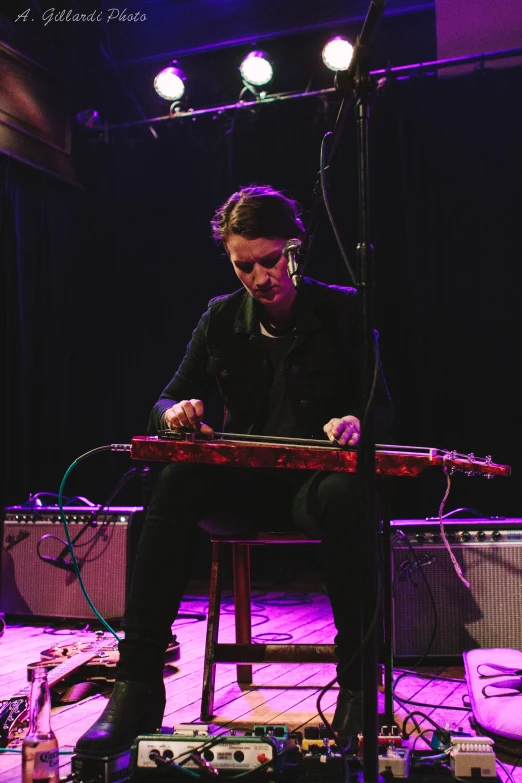 a man in a black jacket is playing a keyboard