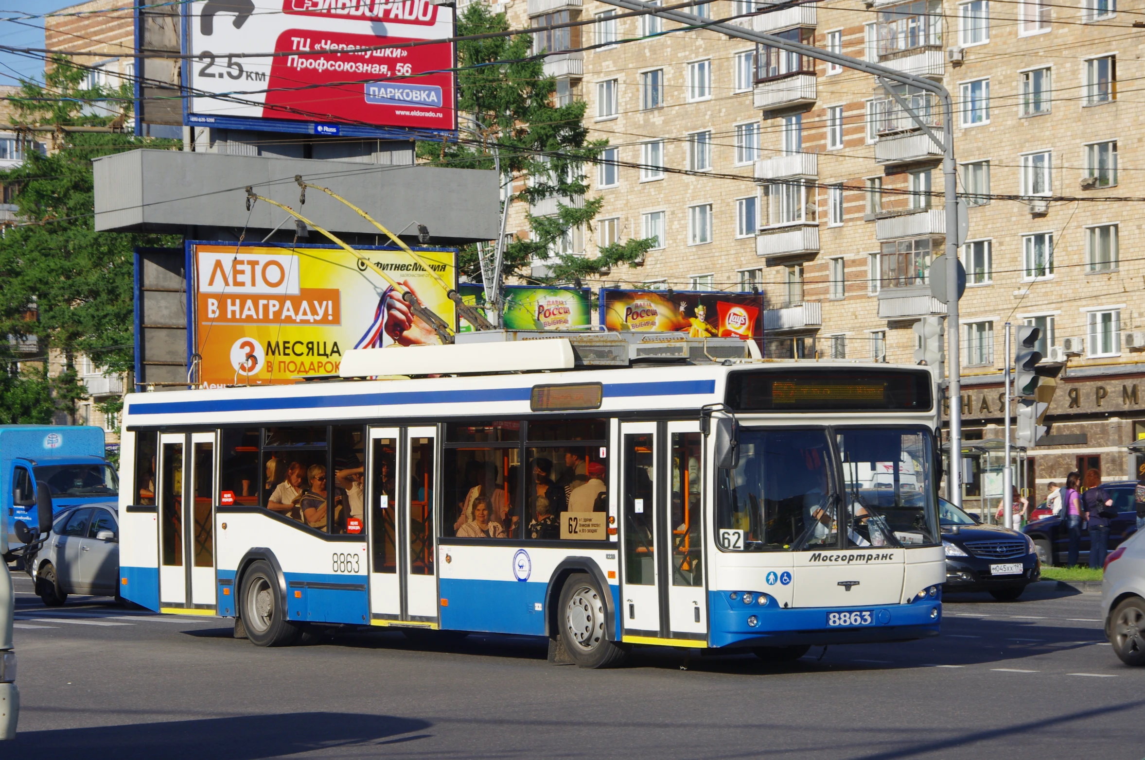 a bus turning a corner in the street near other cars