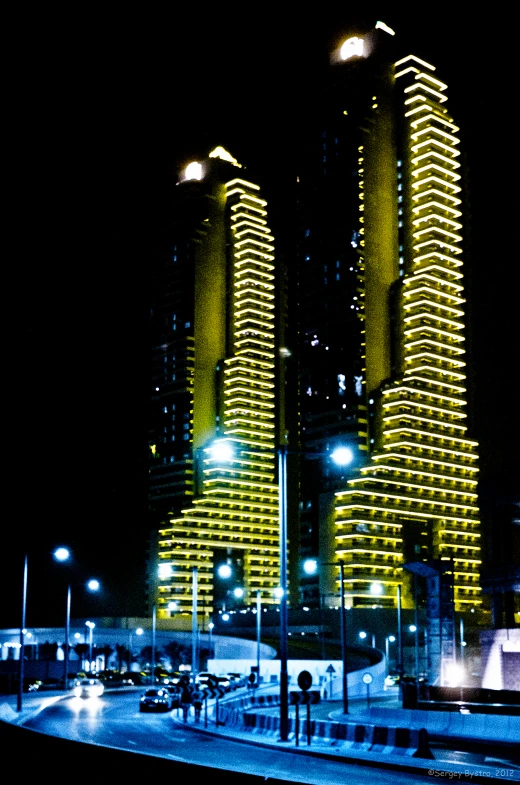 a very tall building lit up by street lights