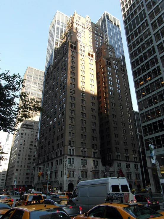 many cars and trucks driving on a street in front of a high rise building