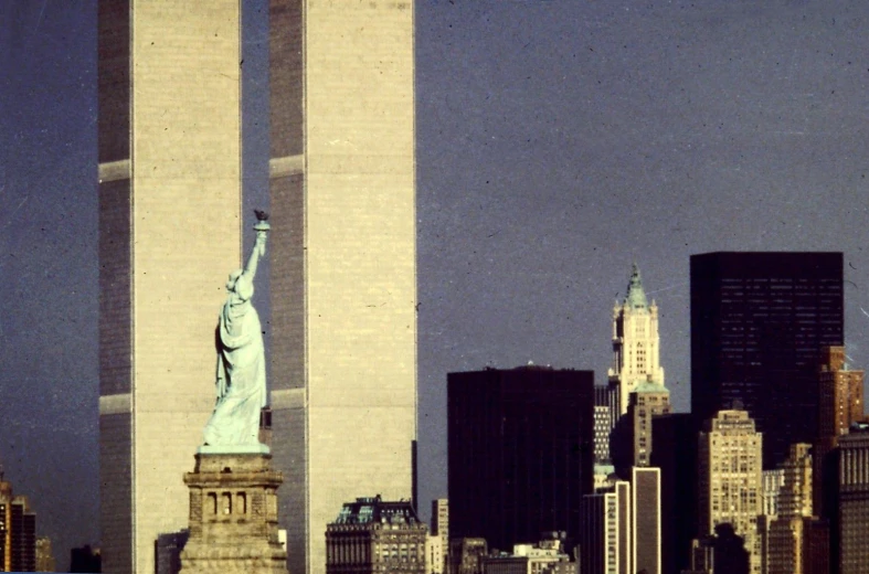 the statue of liberty is shown next to large buildings