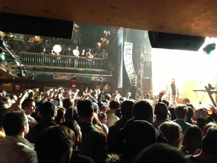 a crowd of people standing in front of stage lights