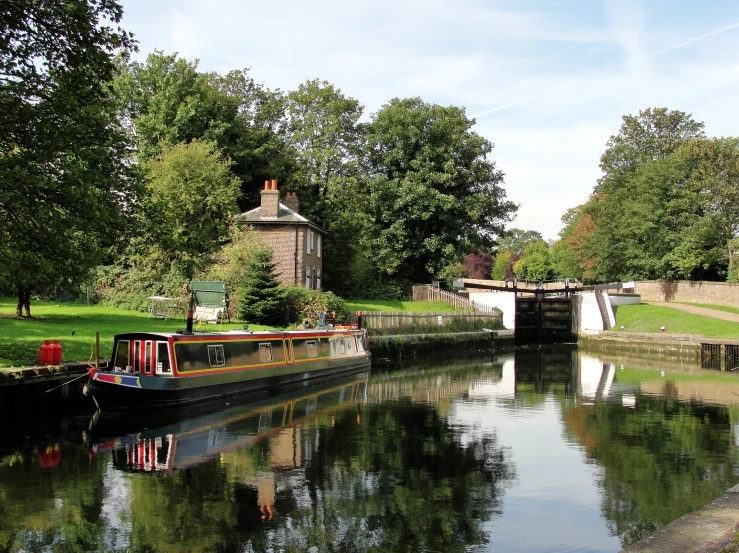 a small house boat on a river in the middle of a park