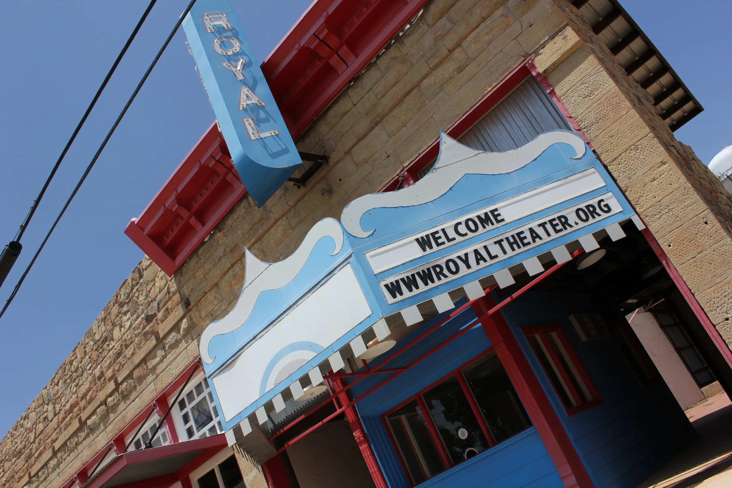 the entrance to a theater on a sunny day