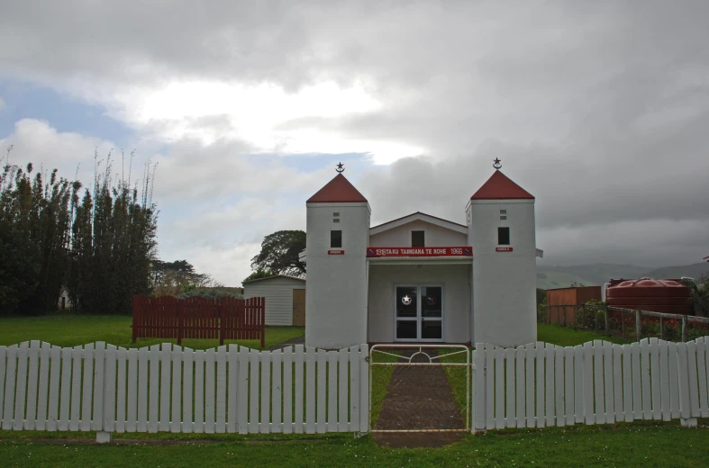 a white fence in front of a small church