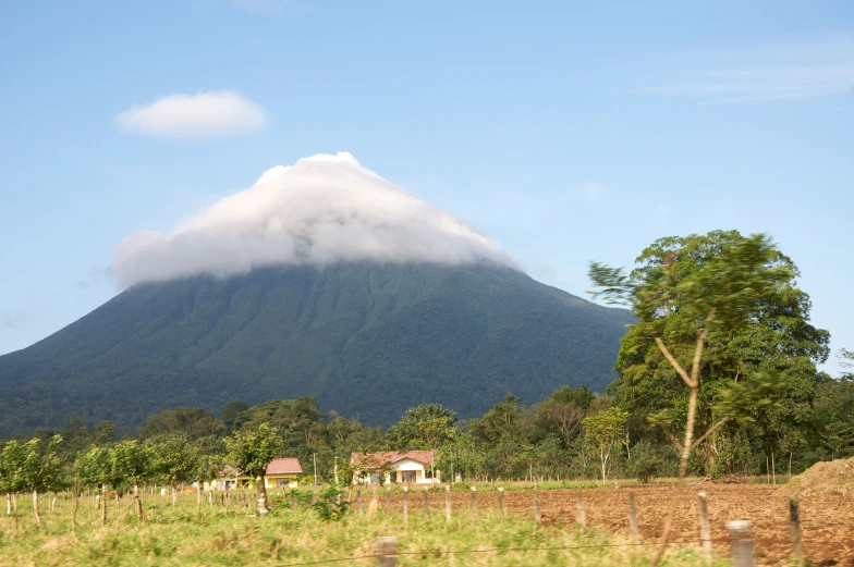 a large mountain is in the distance under clouds