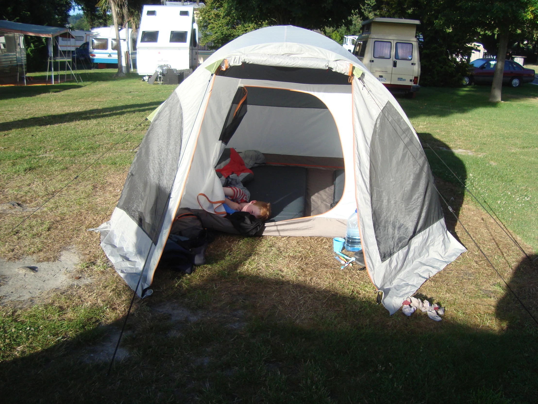 a person laying inside a tent on a field