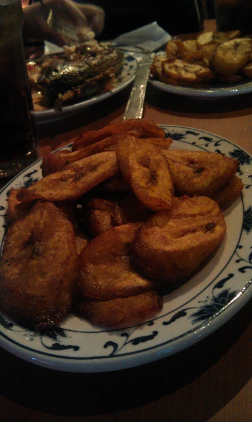 plate with a pile of fried food next to some drinks