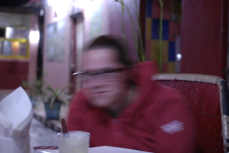 a blurry image of a person wearing glasses eating