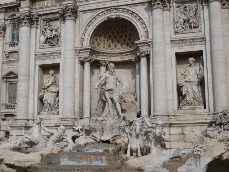 an ornate stone fountain with statues on it