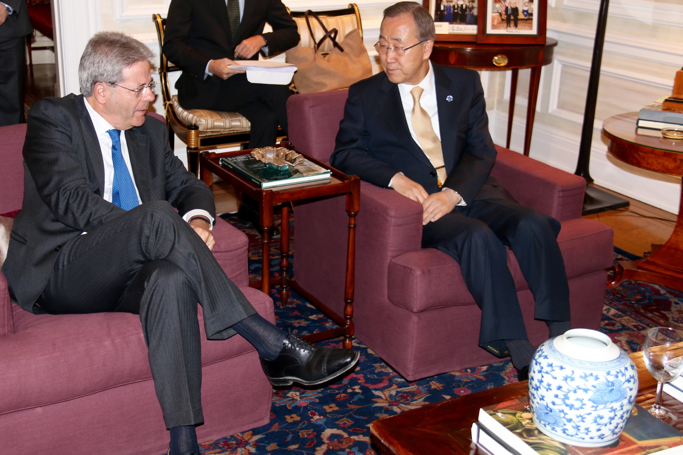 two men in suits sitting in a room