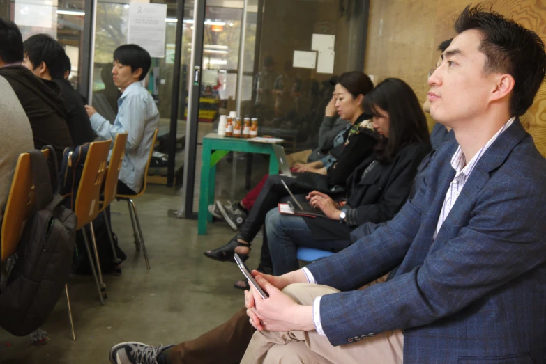 an asian man is sitting at a table talking