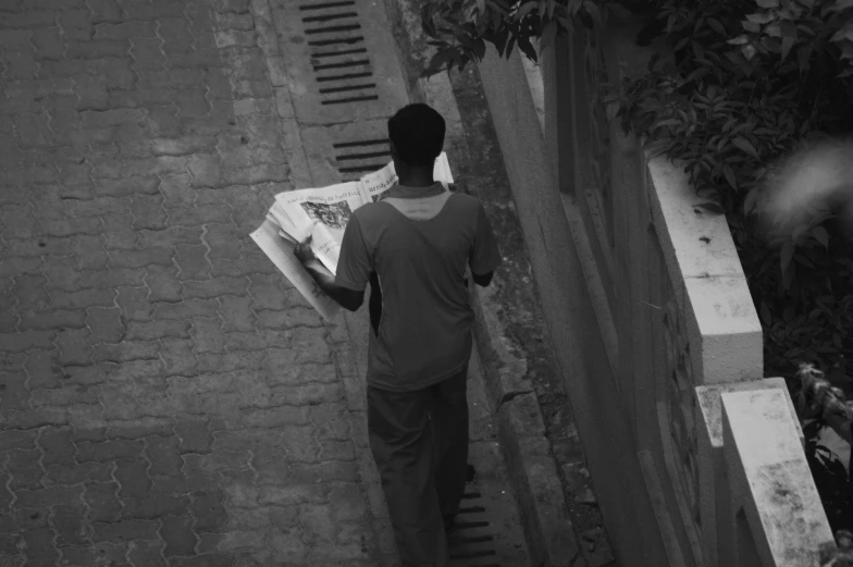 a man walking down the street holding onto his books