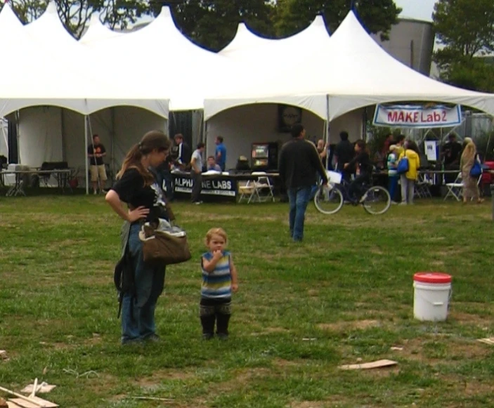 an adult and child in front of some tents