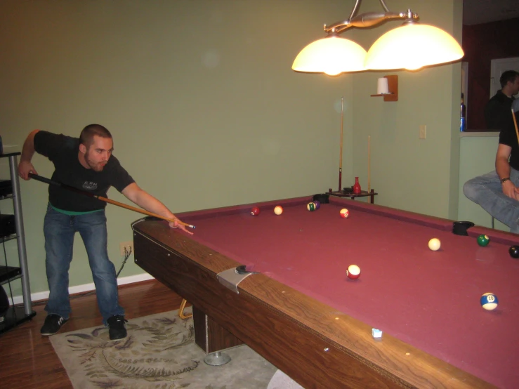 two guys are playing pool at the party