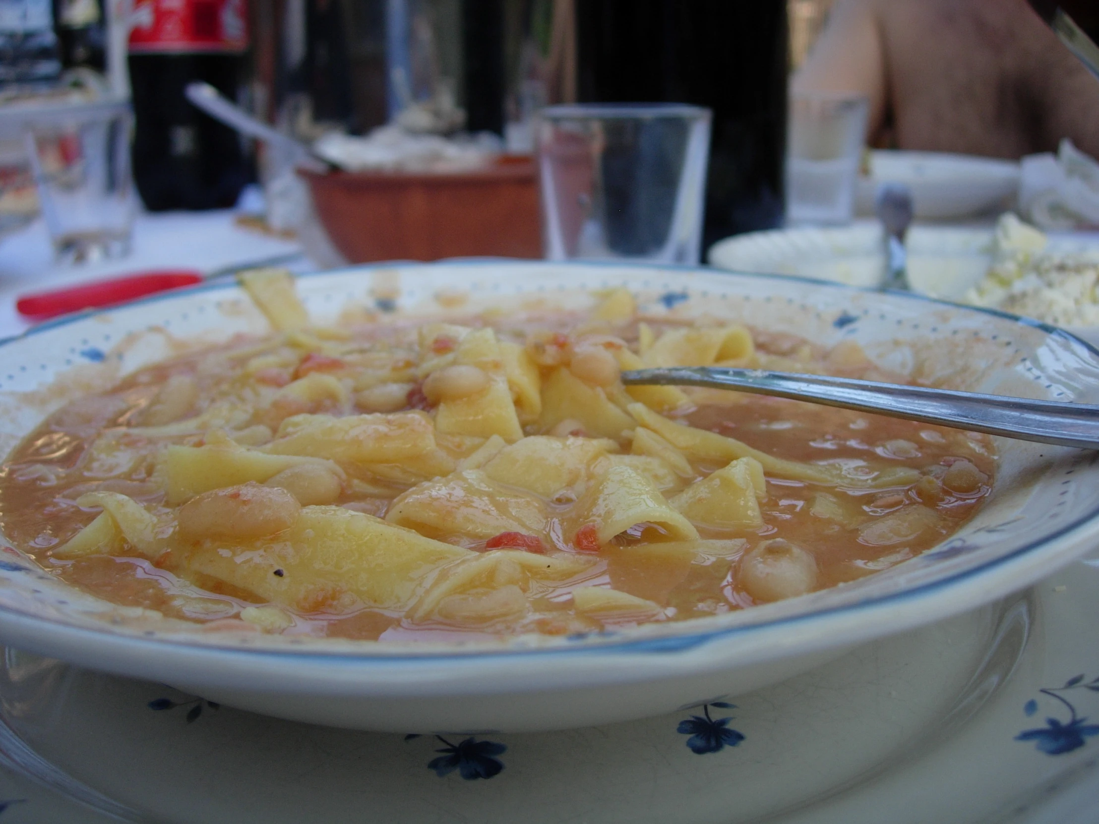 a bowl of soup in a dish with two spoons