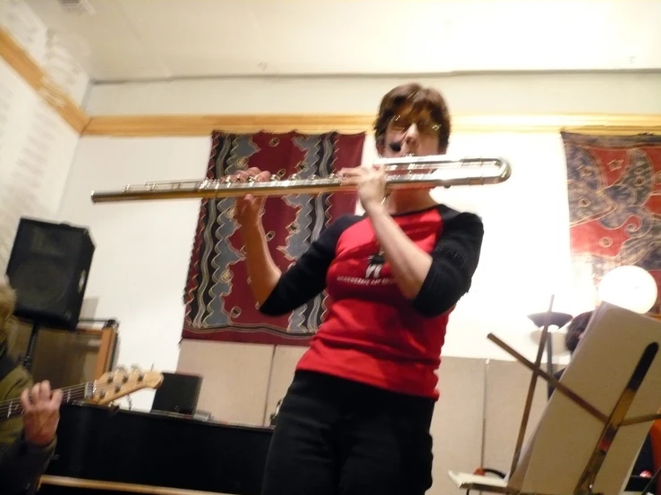 the woman plays a trombone while people watch