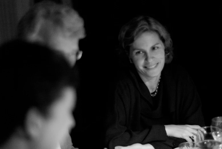 a woman in black dress sitting at a table