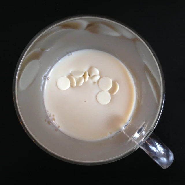 a coffee cup filled with liquid on top of a black table