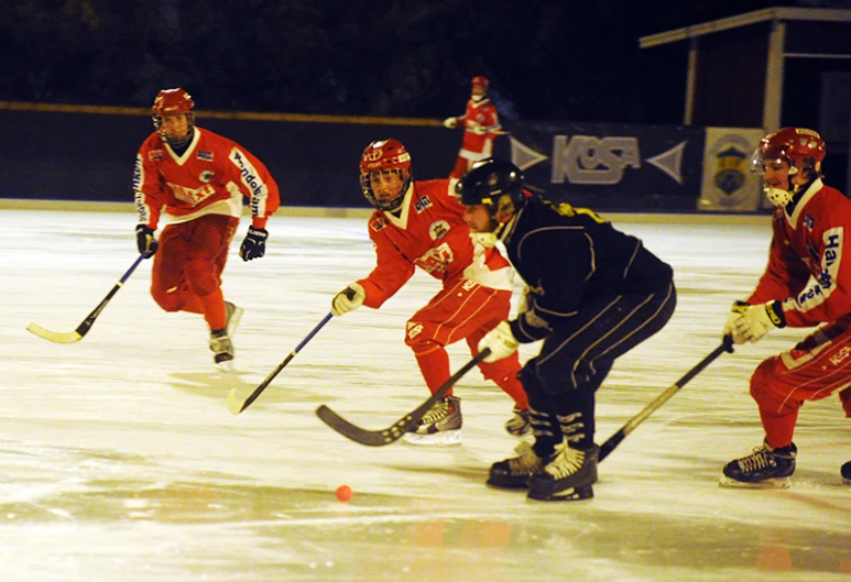 four people playing a game of hockey in the middle of an ice rink
