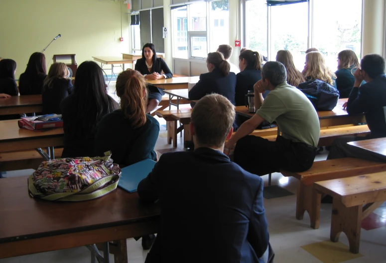 a room full of people are sitting and talking