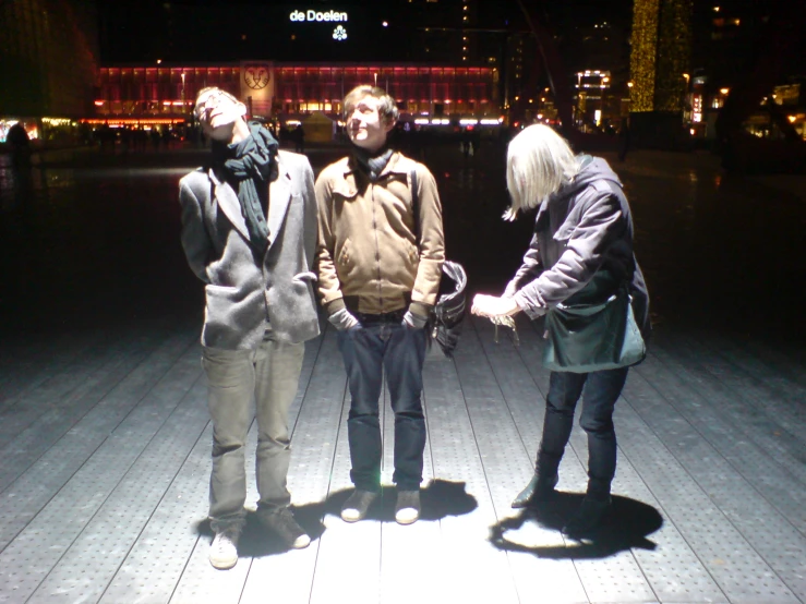 three people standing on a floor looking off into the distance