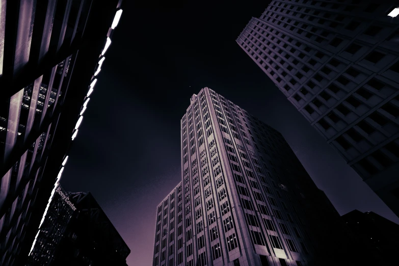 two large buildings with lights on, in the distance