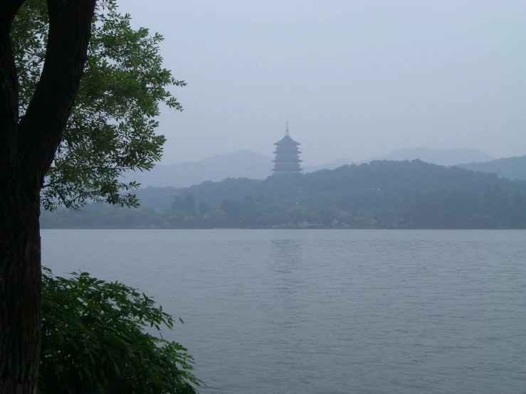 pagoda near body of water on cloudy day