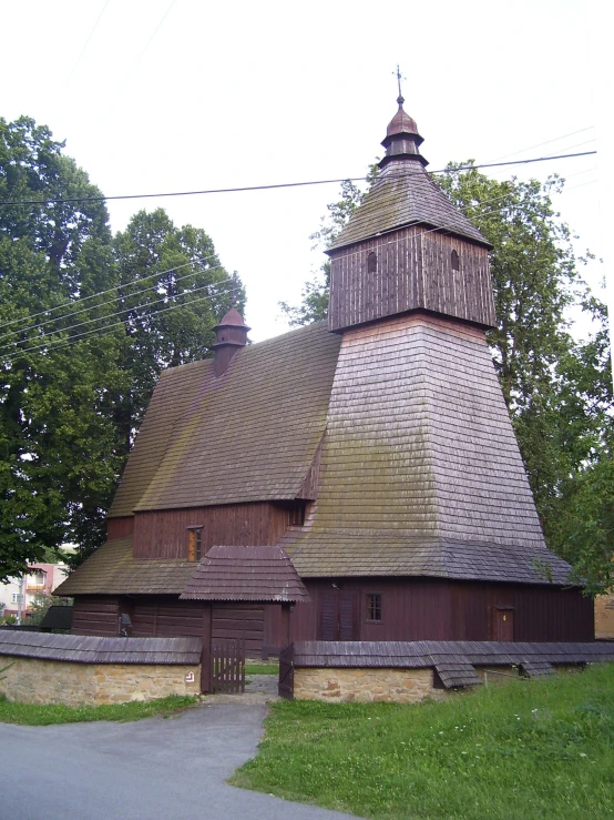 an old barn with a steeple and green grass
