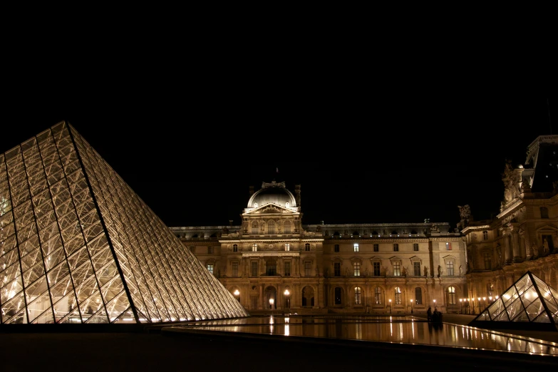 two large pyramids on a building at night