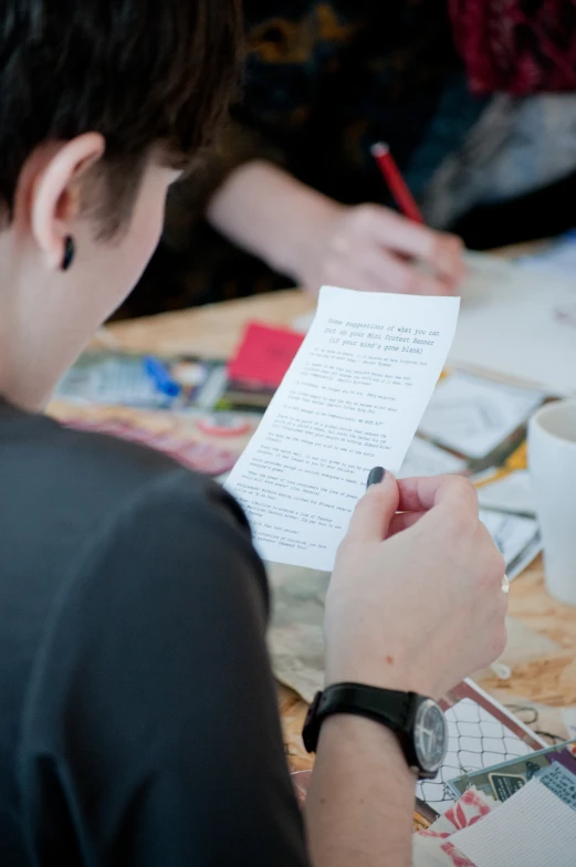 someone writing on a piece of paper with a pen