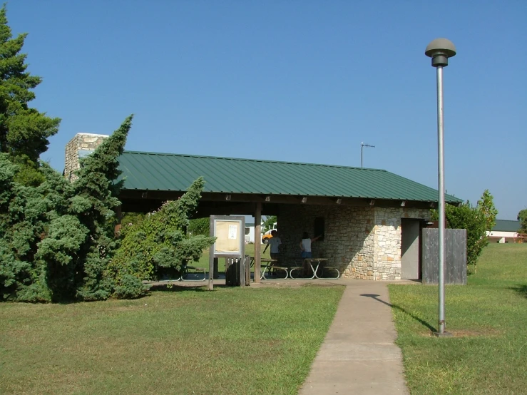 there is a small stone building on the edge of a walkway