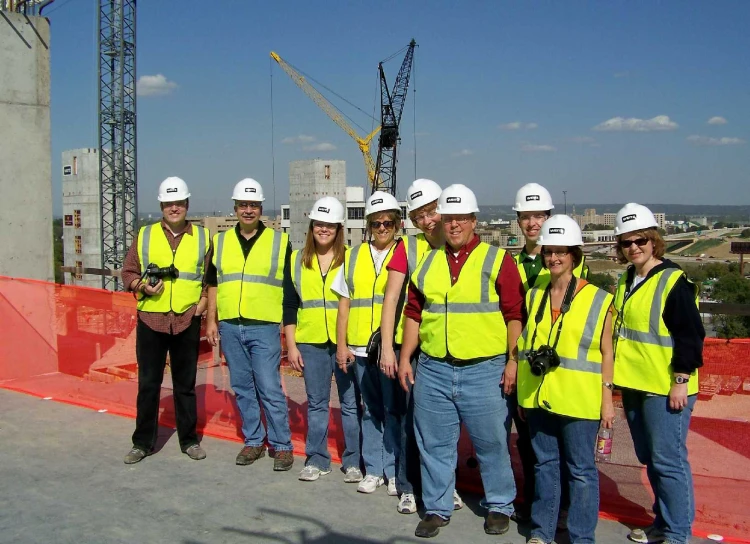 people in hard hats are standing at the construction site