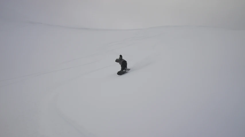 a person is snowboarding on a cloudy day