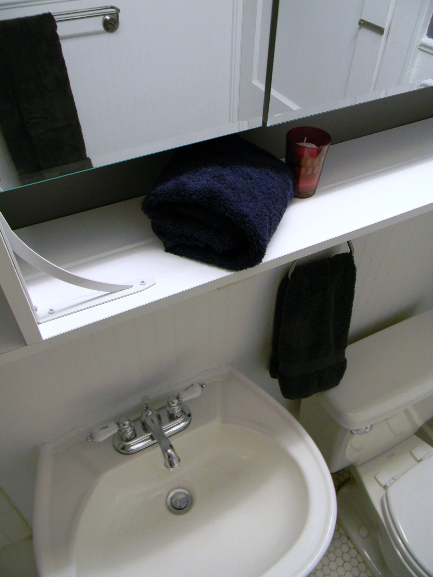 a towel sitting on top of a toilet next to a white sink