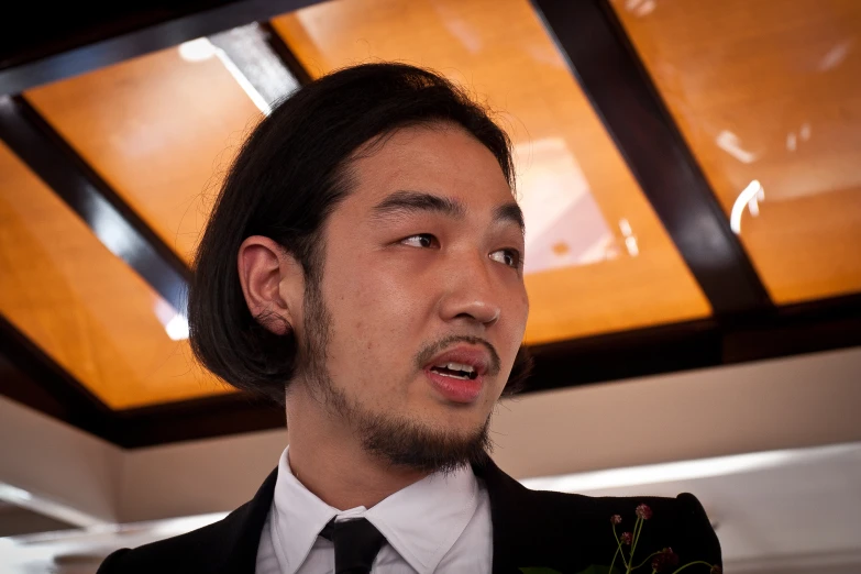 a close up of a man wearing a suit and tie