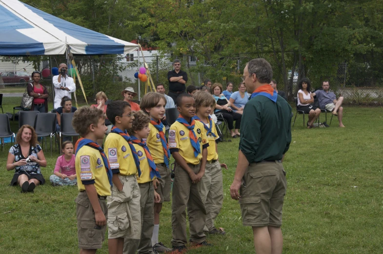 a group of boys that are standing in the grass