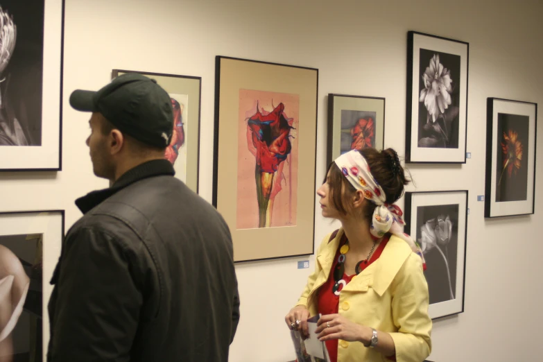 two people are looking at art on a wall