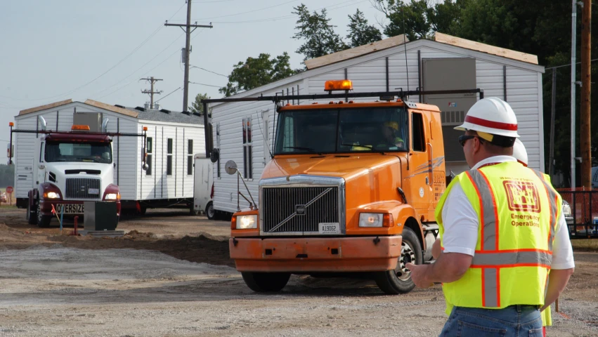 an orange truck and a small white trailer