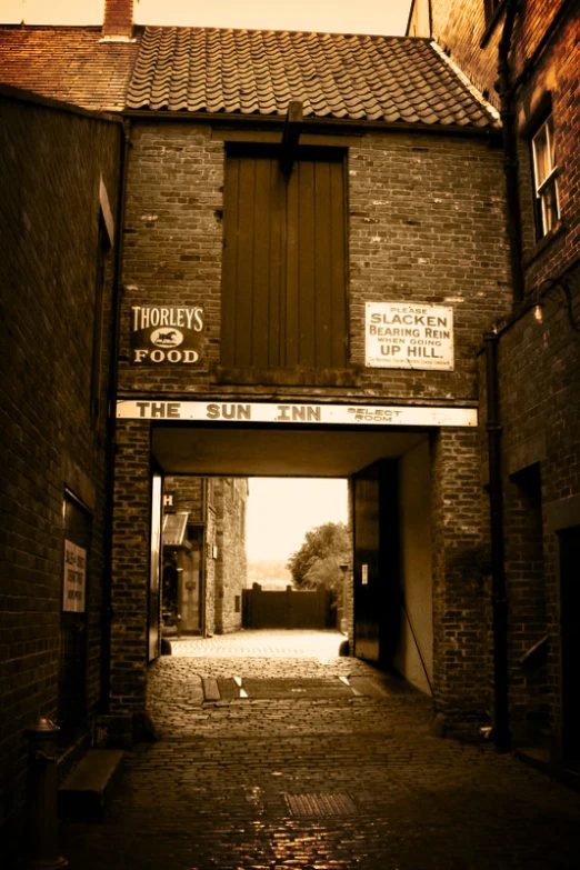 a tunnel leading to an alley in a brick building