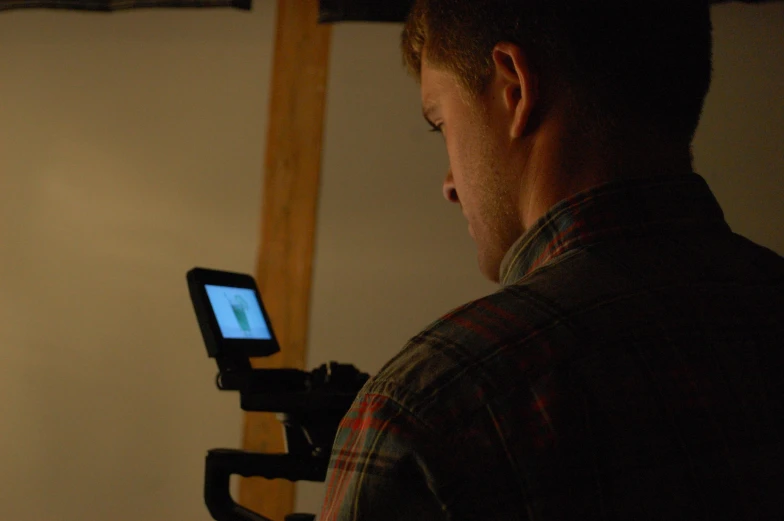 a man is holding up a small tablet computer