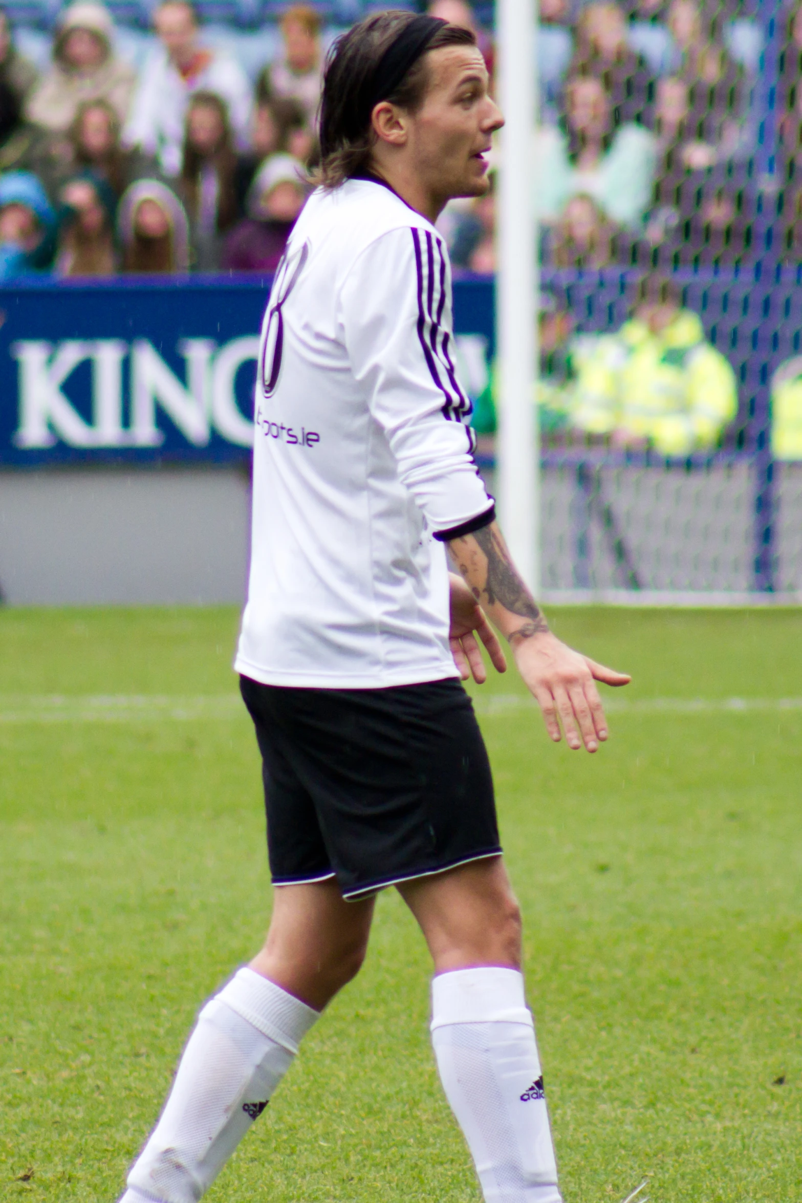 a soccer player in a white uniform holding his hands out